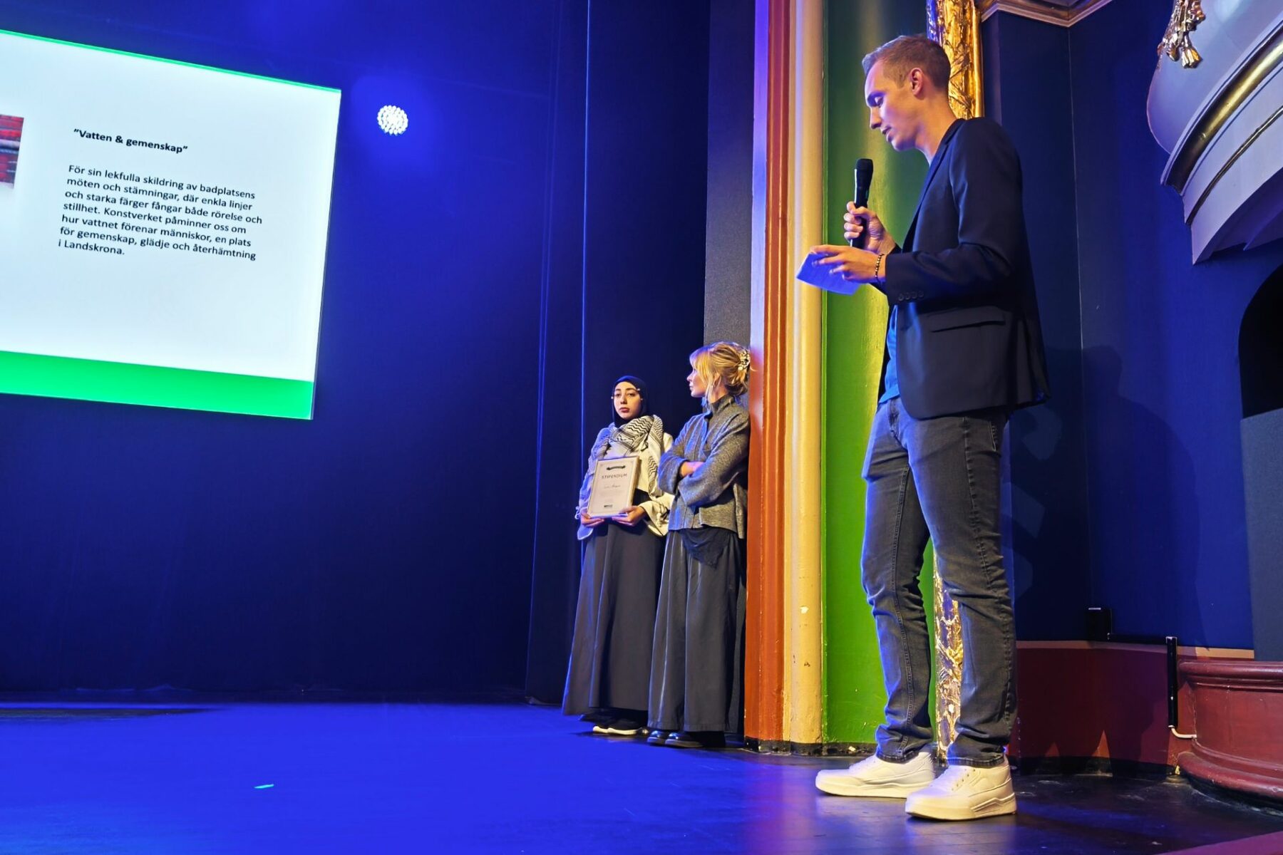 Tre personer på en scen under prisutdelning