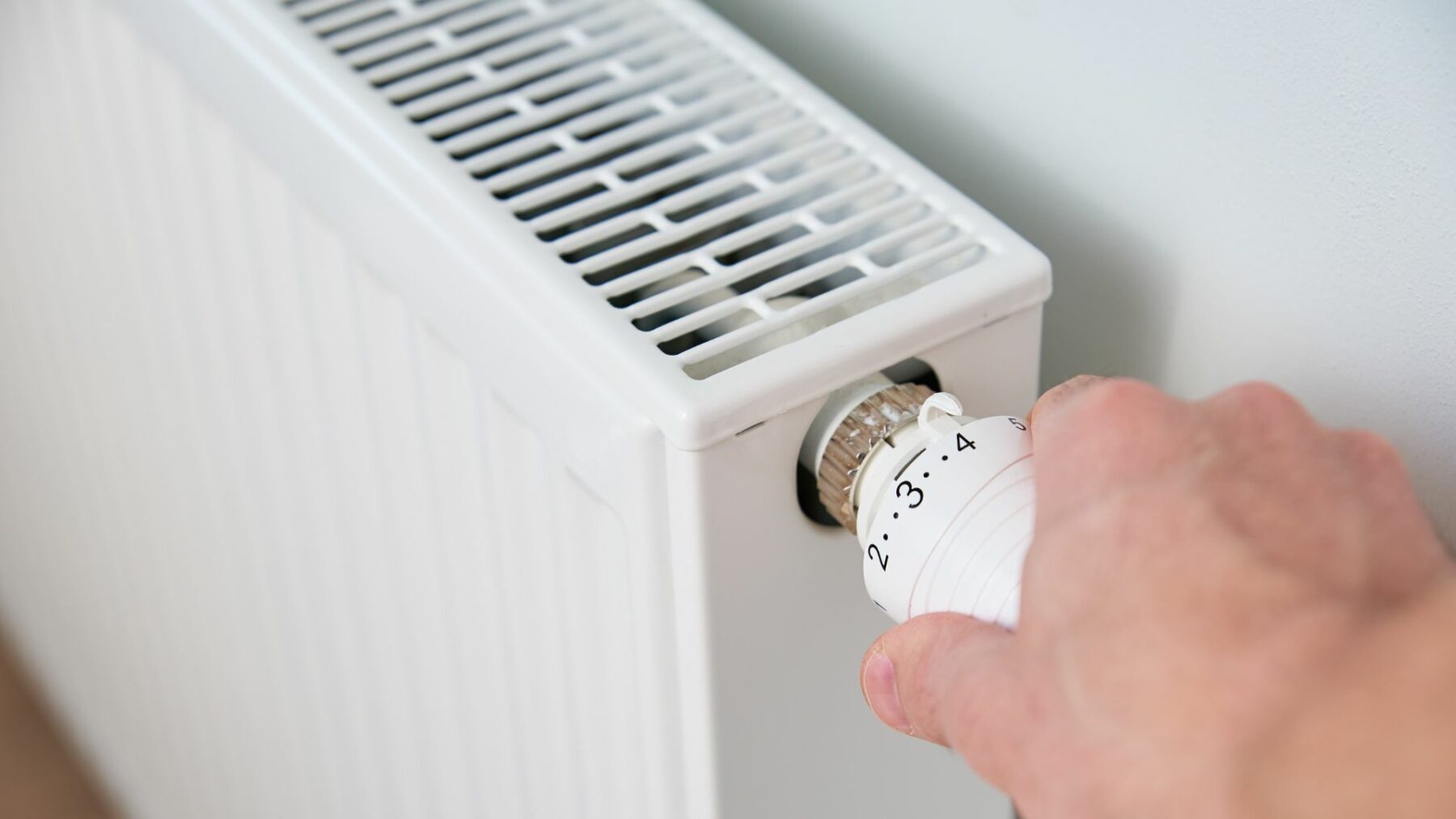 Hand vrider om reglage på radiator