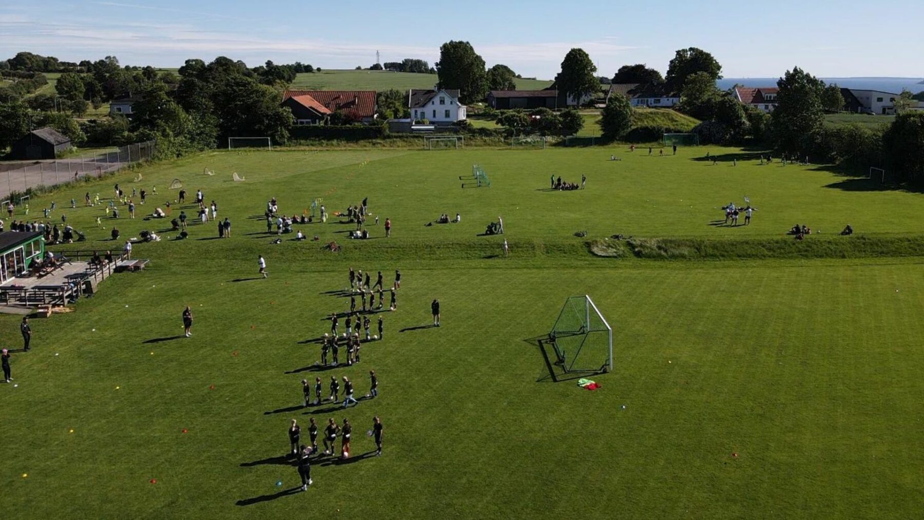 Fotbollsträning på en gräsplan med flera grupper deltagare